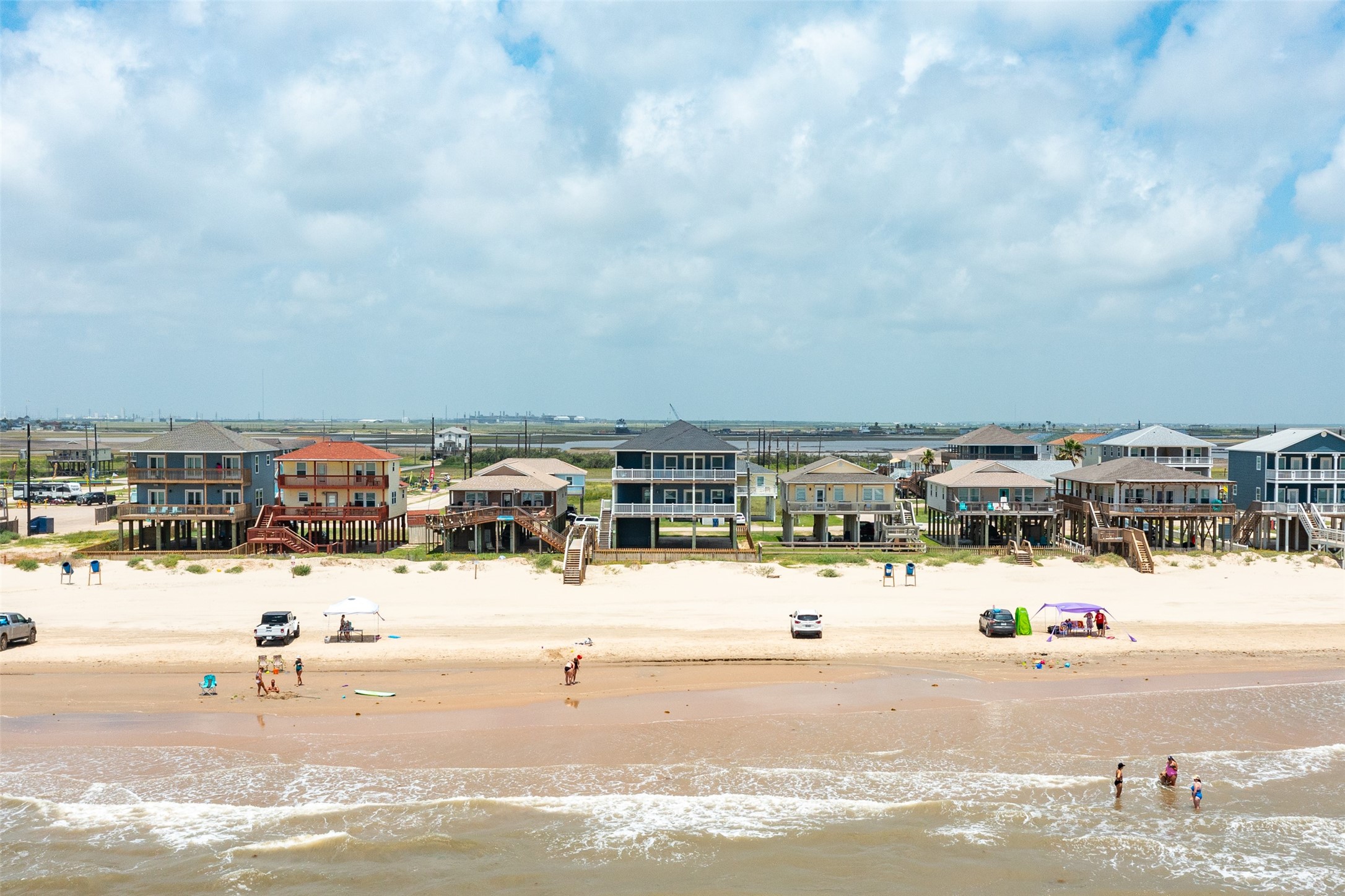 109 A Santar Loop, Unit A Surfside Beach, TX 77541 - Photo 6 of 43 Beachfront view with elevated homes on stilts, offering direct access to a sandy beach. Ideal for seaside living with a picturesque ocean backdrop.