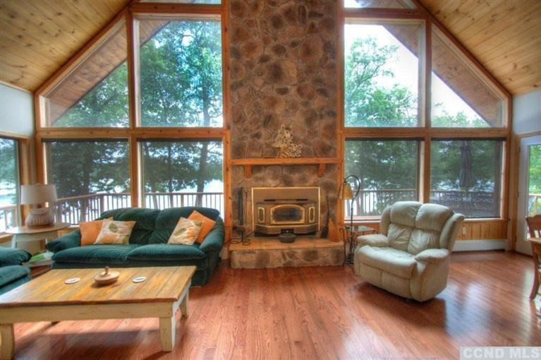 33 Golf Course Road Copake, NY 12521 - Photo 7 of 10 a living room with a fireplace and a floor to ceiling window