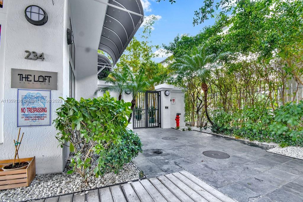 234 Northeast 3rd Street, Unit 507 Miami, FL 33132 - Photo 2 of 48 a view of a house with potted plants and a large tree