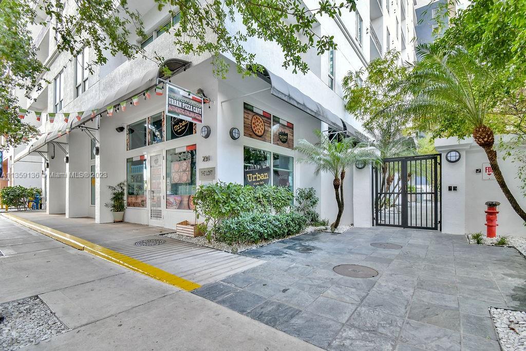 234 Northeast 3rd Street, Unit 507 Miami, FL 33132 - Photo 3 of 48 a view of a white house with a large tree and plants