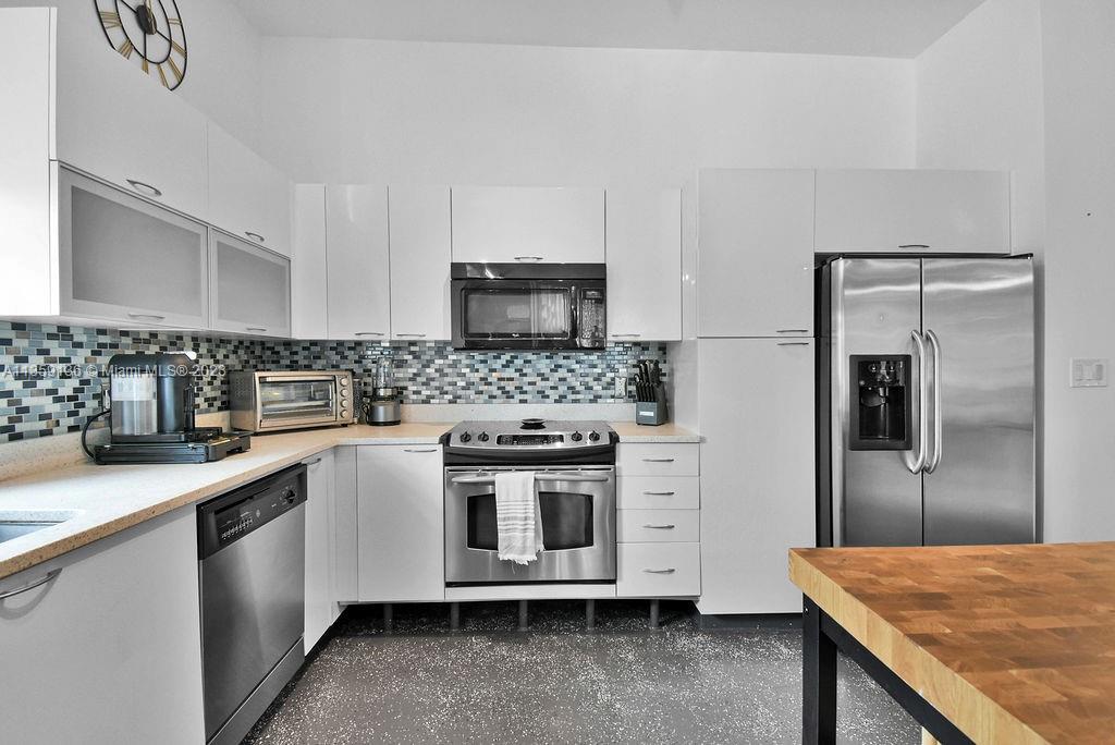 234 Northeast 3rd Street, Unit 507 Miami, FL 33132 - Photo 32 of 48 a kitchen with stainless steel appliances granite countertop a sink stove and refrigerator
