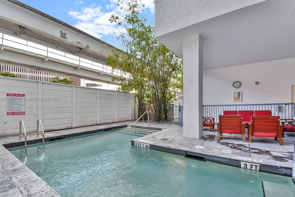 234 Northeast 3rd Street, Unit 507 Miami, FL 33132 - Photo 40 of 48 a backyard with wooden fence and a bench