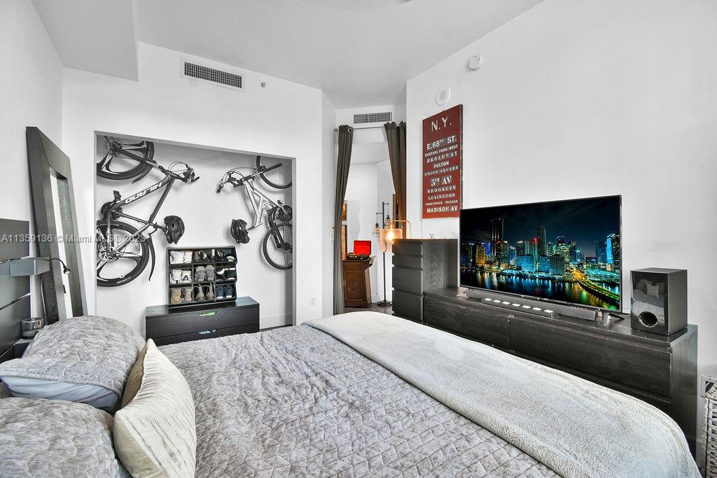 234 Northeast 3rd Street, Unit 507 Miami, FL 33132 - Photo 10 of 48 a bedroom with a bed and a flat screen tv