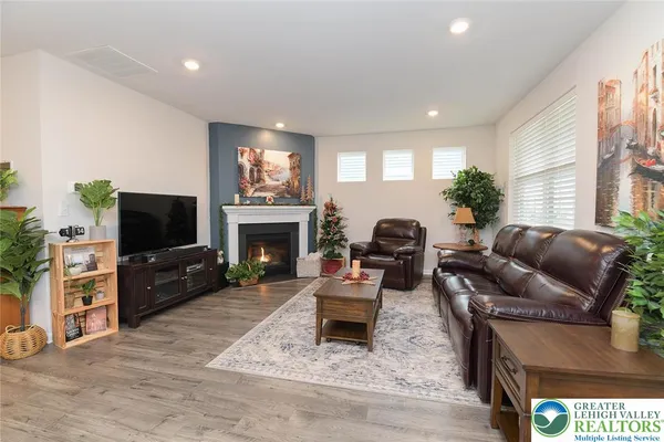 a living room with furniture a flat screen tv and a fireplace