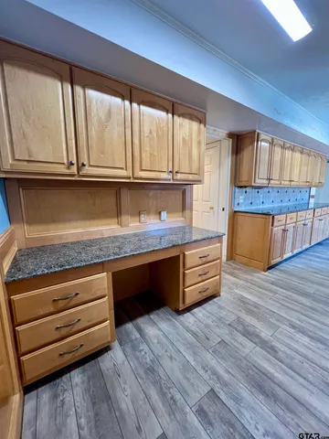 a kitchen with granite countertop wooden floors and wide window