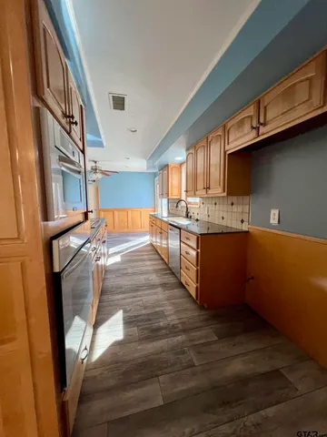 a kitchen with stainless steel appliances granite countertop a stove and a refrigerator