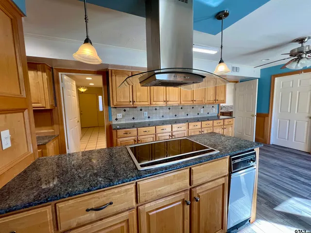 a kitchen with stainless steel appliances granite countertop a sink a stove and a wooden floors