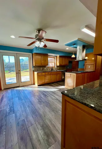 a kitchen with stainless steel appliances granite countertop a oven a stove and a wooden floors