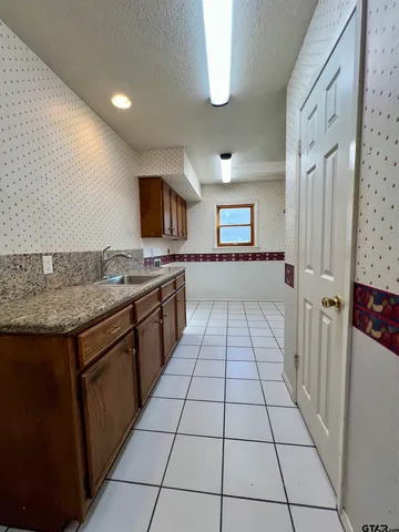 a kitchen with a sink a stove top oven and cabinets