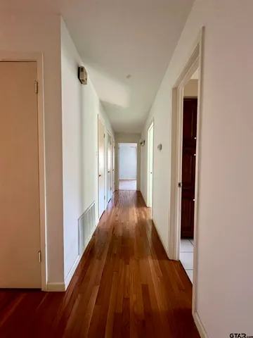 a view of a hallway with wooden floor