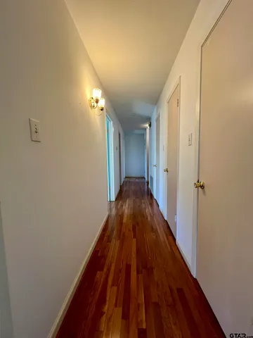 a view of a hallway with wooden floor