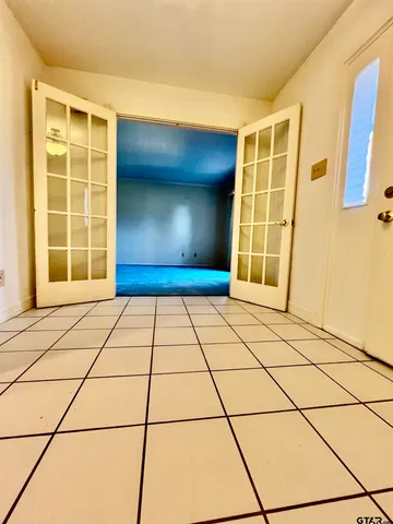 a view of empty room with windows and refrigerator