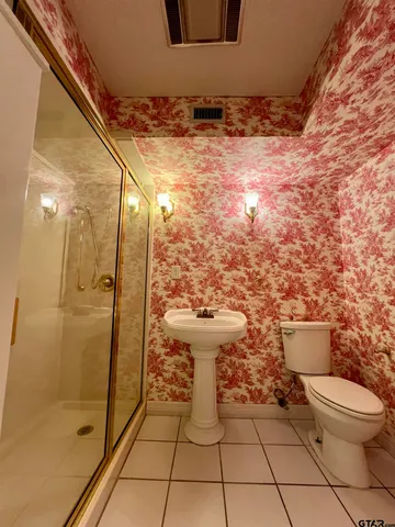a bathroom with a toilet and a shower