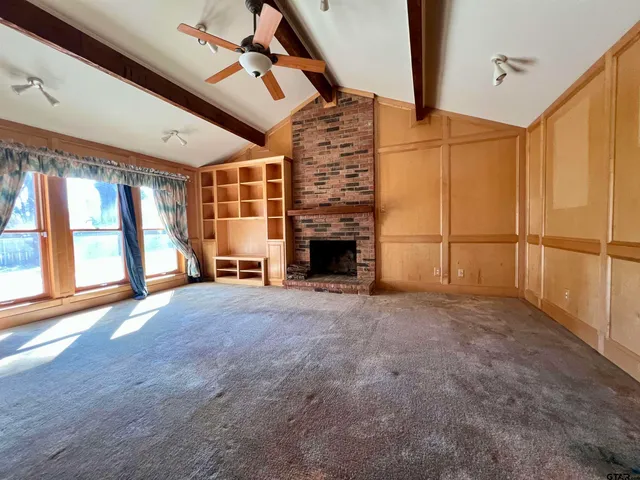 a view of an empty room with a fireplace and a window