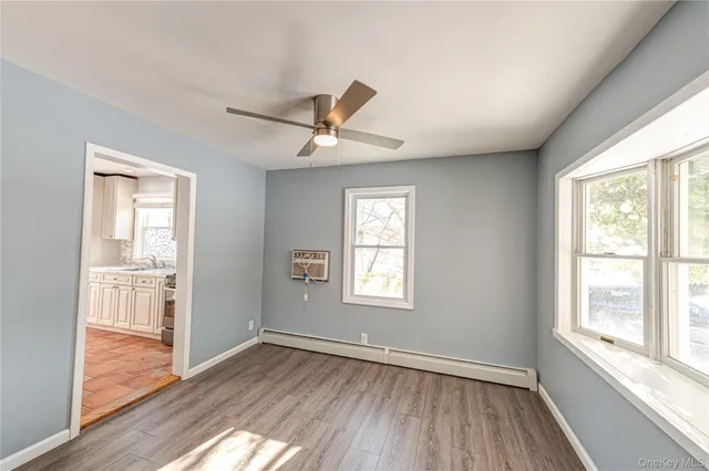 a view of a livingroom with wooden floor and a window