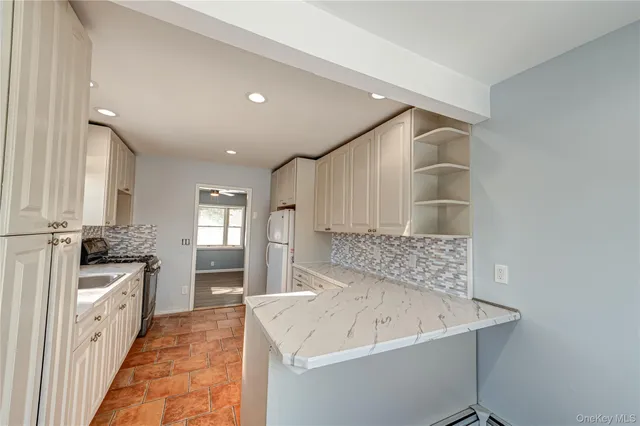 a spacious bathroom with a granite countertop sink a mirror and a bathtub