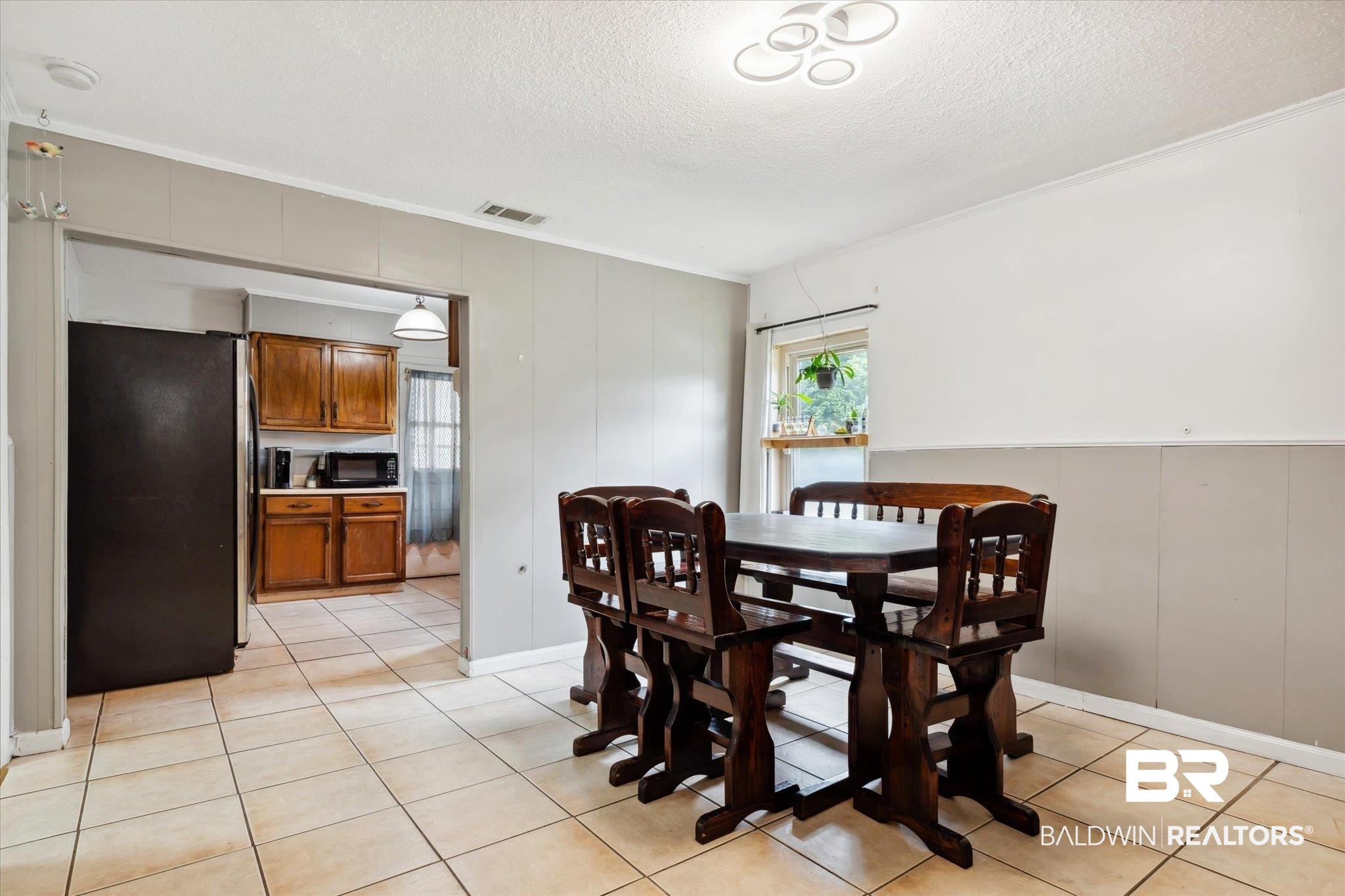 4851 Lesure Road Theodore, AL 36582 - Photo 6 of 21 Dining space featuring ornamental molding, light tile patterned floors, and a textured ceiling