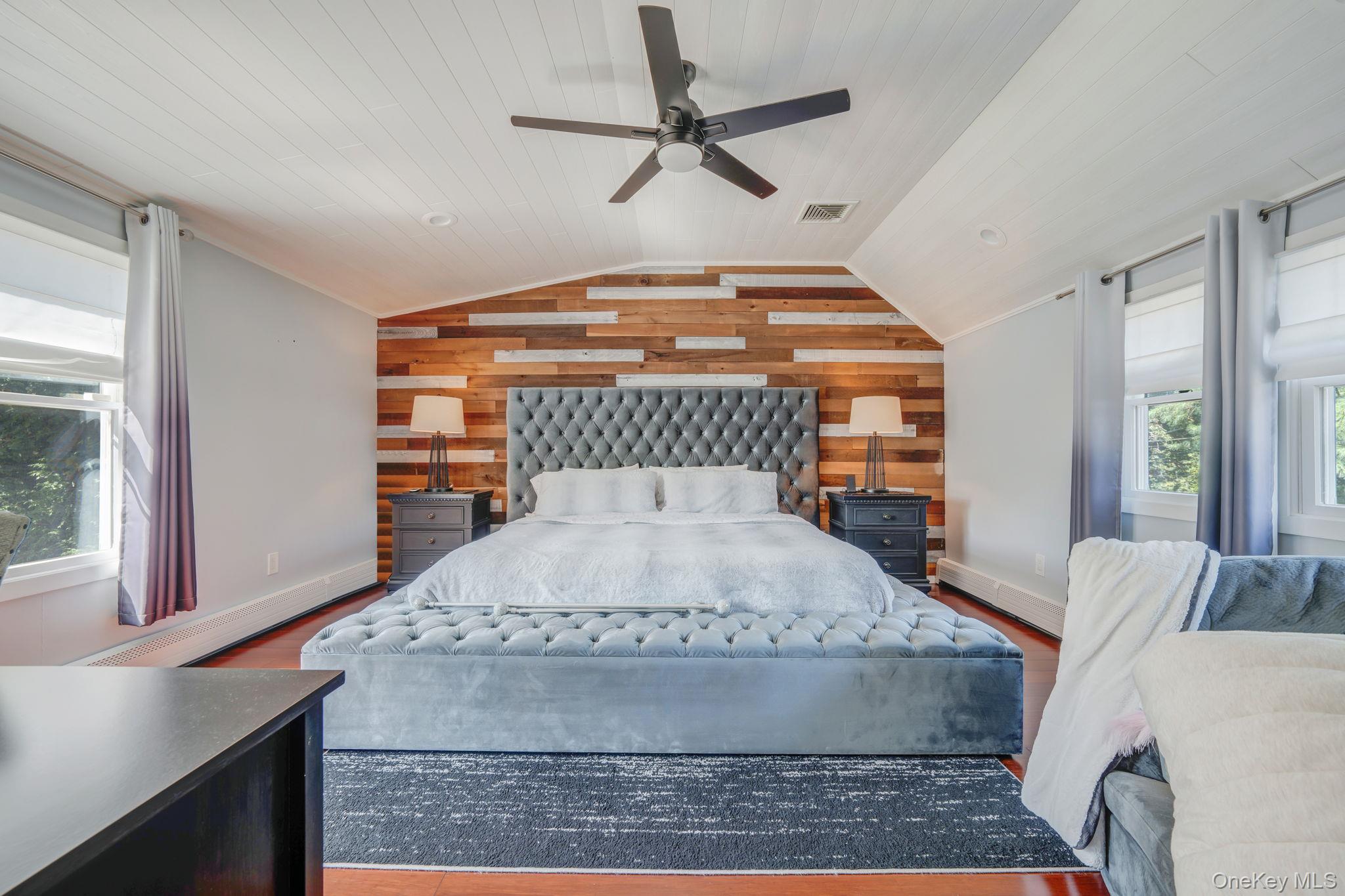 183 Old Country Road Speonk, NY 11972 - Photo 17 of 48 Bedroom with wooden walls, vaulted ceiling, wood finished floors, and a ceiling fan