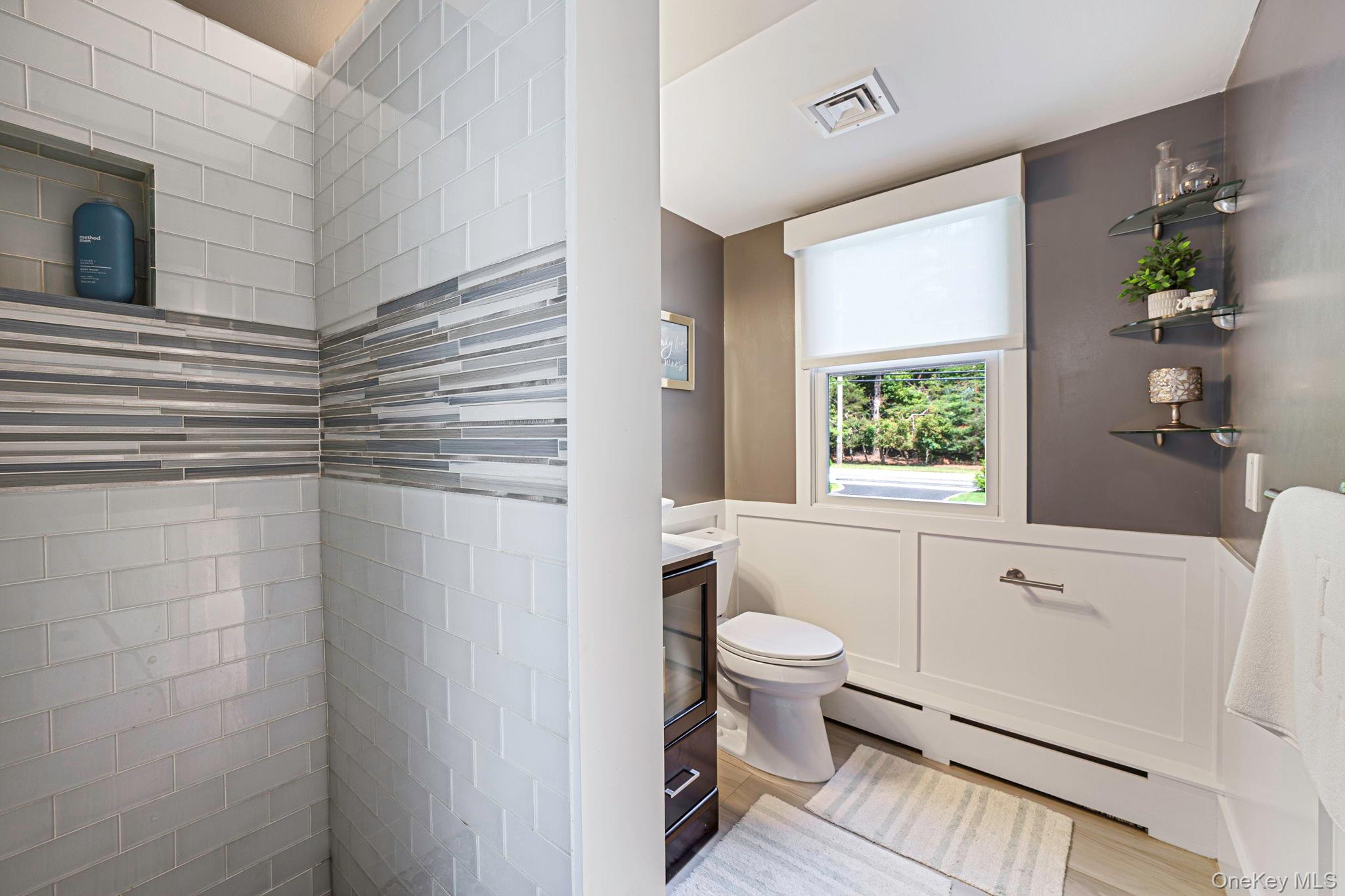 183 Old Country Road Speonk, NY 11972 - Photo 31 of 48 Bathroom with vanity, a baseboard heating unit, wainscoting, and light wood-style flooring