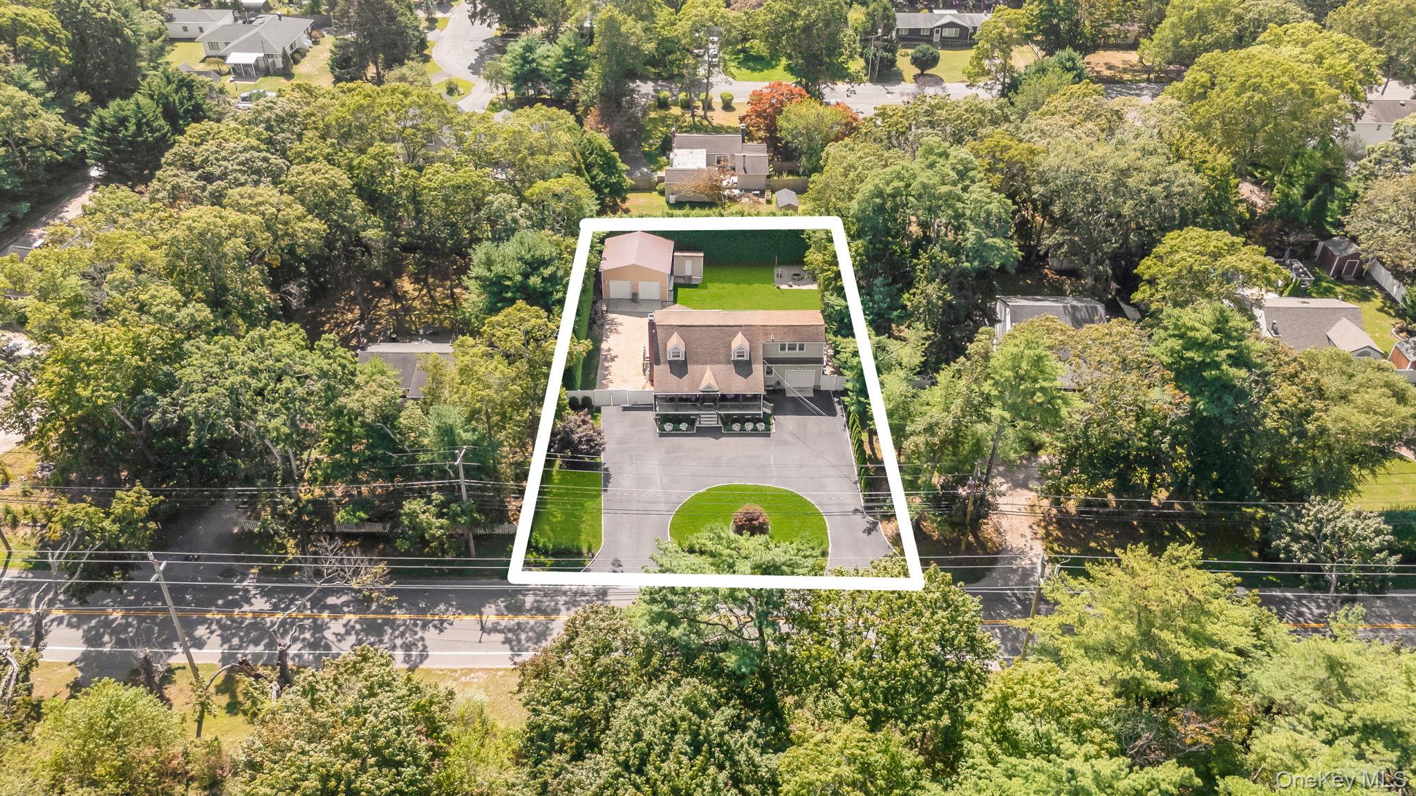 183 Old Country Road Speonk, NY 11972 - Photo 38 of 48 Aerial view of residential area with property parcel outlined and a tree filled landscape