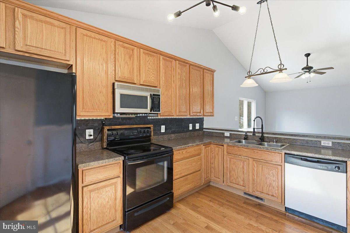 11585 Big Sandy Road Lusby, MD 20657 - Photo 13 of 48 a kitchen with stainless steel appliances granite countertop a sink stove and microwave