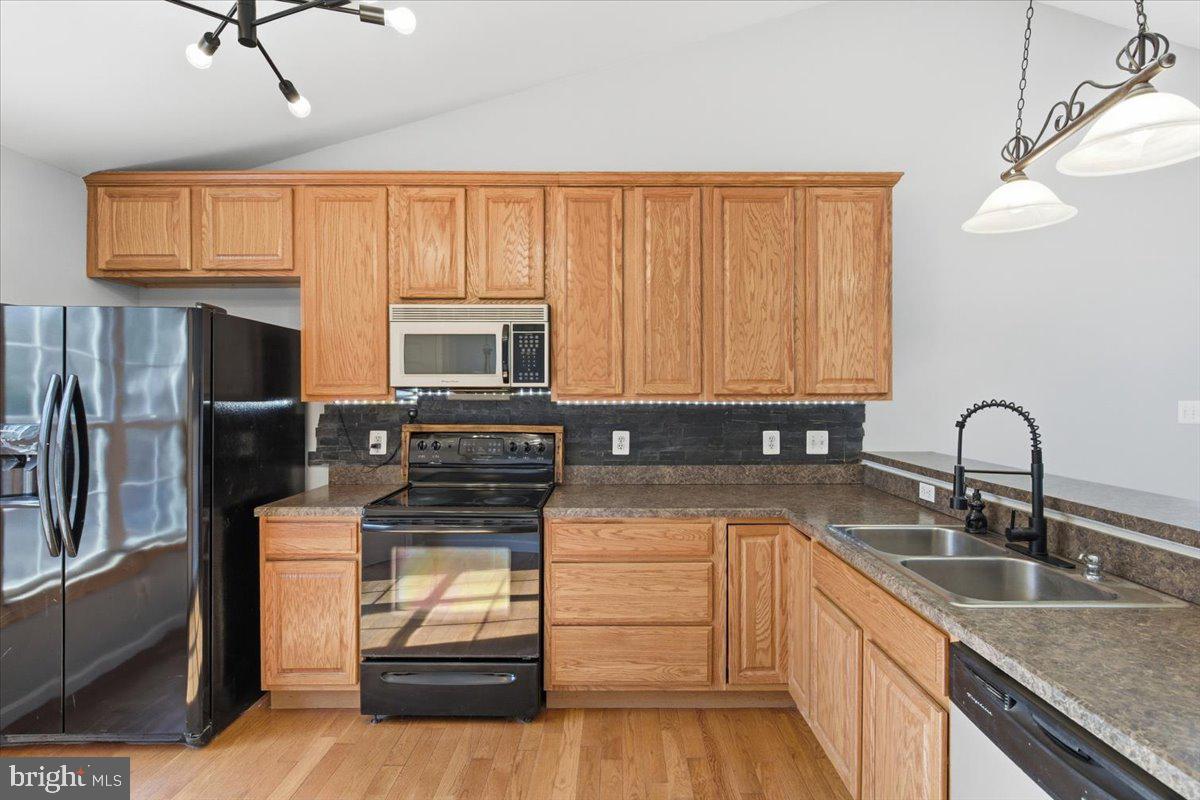 11585 Big Sandy Road Lusby, MD 20657 - Photo 14 of 48 a kitchen with stainless steel appliances granite countertop a sink stove and refrigerator