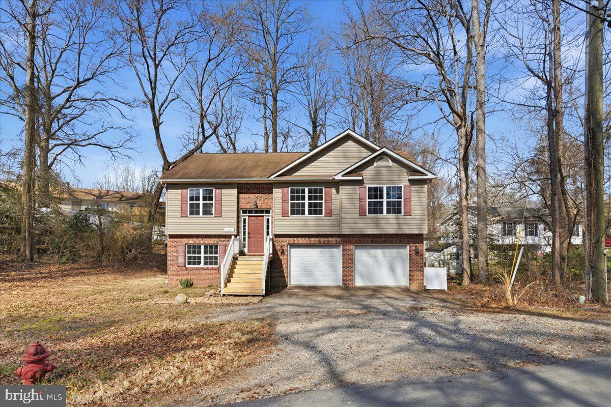 11585 Big Sandy Road Lusby, MD 20657 - Photo 2 of 48 a front view of a house with a yard and garage
