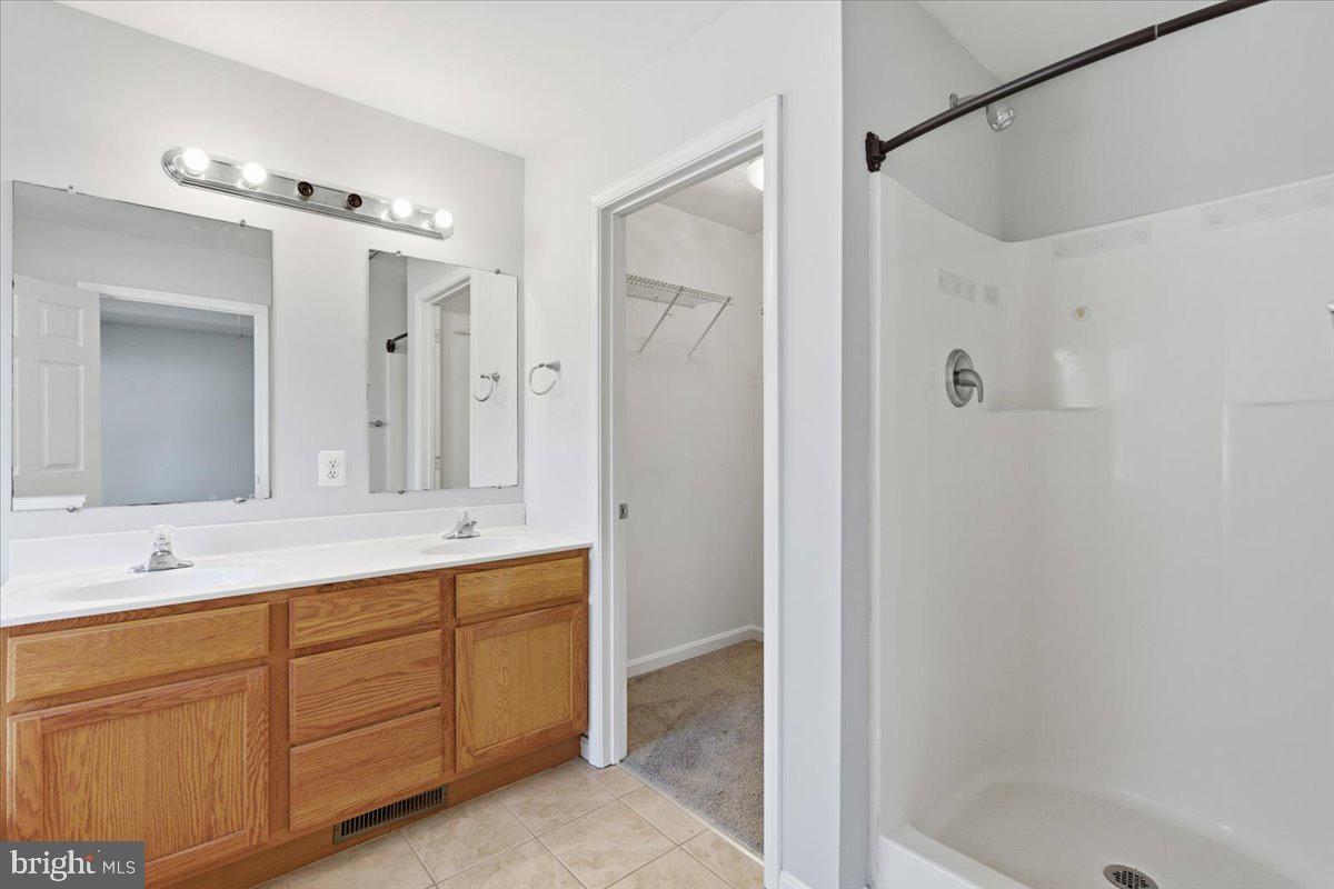 11585 Big Sandy Road Lusby, MD 20657 - Photo 23 of 48 a bathroom with a granite countertop sink a mirror a shower and a bathtub