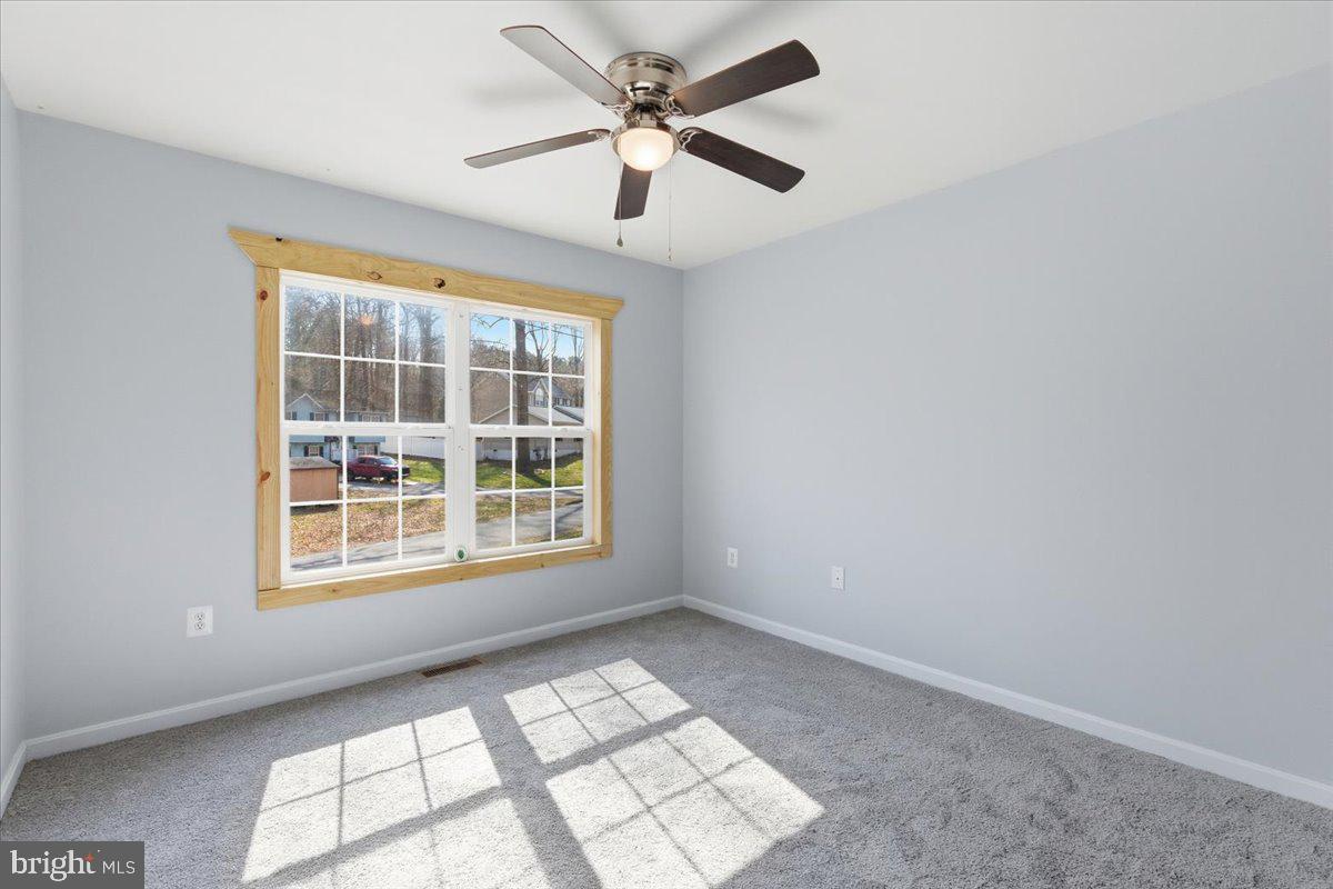 11585 Big Sandy Road Lusby, MD 20657 - Photo 29 of 48 an empty room with chandelier fan and windows