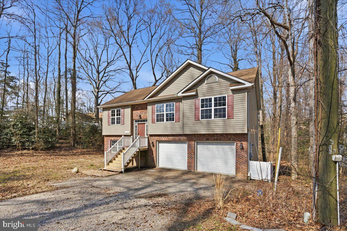11585 Big Sandy Road Lusby, MD 20657 - Photo 3 of 48 a front view of a house with a yard and garage