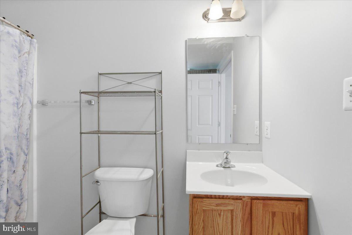 11585 Big Sandy Road Lusby, MD 20657 - Photo 40 of 48 a bathroom with a toilet a sink and mirror
