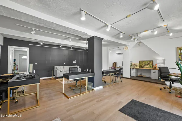 a work room with furniture a flat screen tv and a table