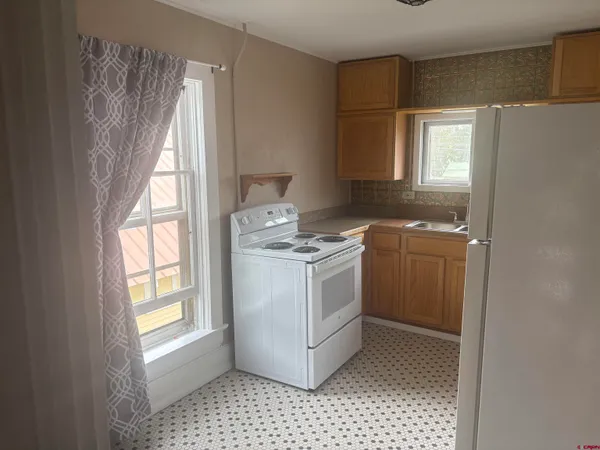 a kitchen with a stove a sink and a window