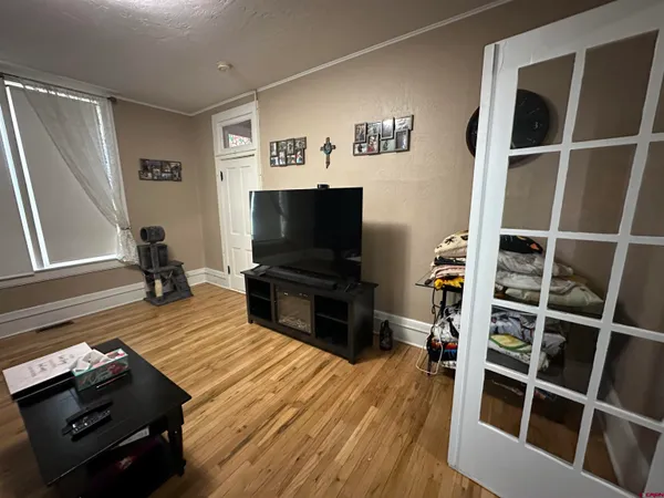 a living room with furniture a flat screen tv and wooden floor