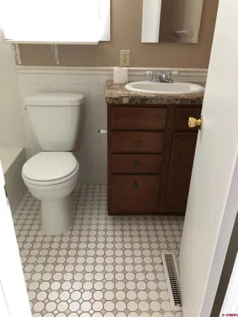 a bathroom with a sink a toilet and mirror