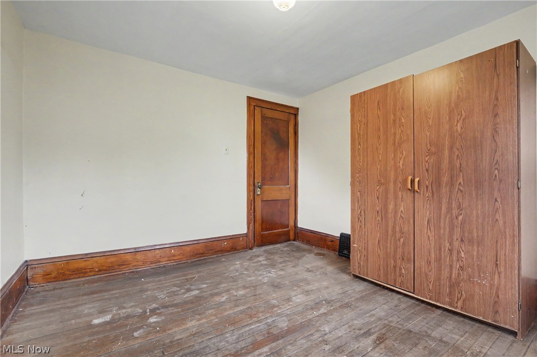 456 Delmar Avenue Akron, OH 44310 - Photo 23 of 27 Bedroom featuring wood-finish flooring, a built-in wardrobe with double doors, and a wood-paneled door