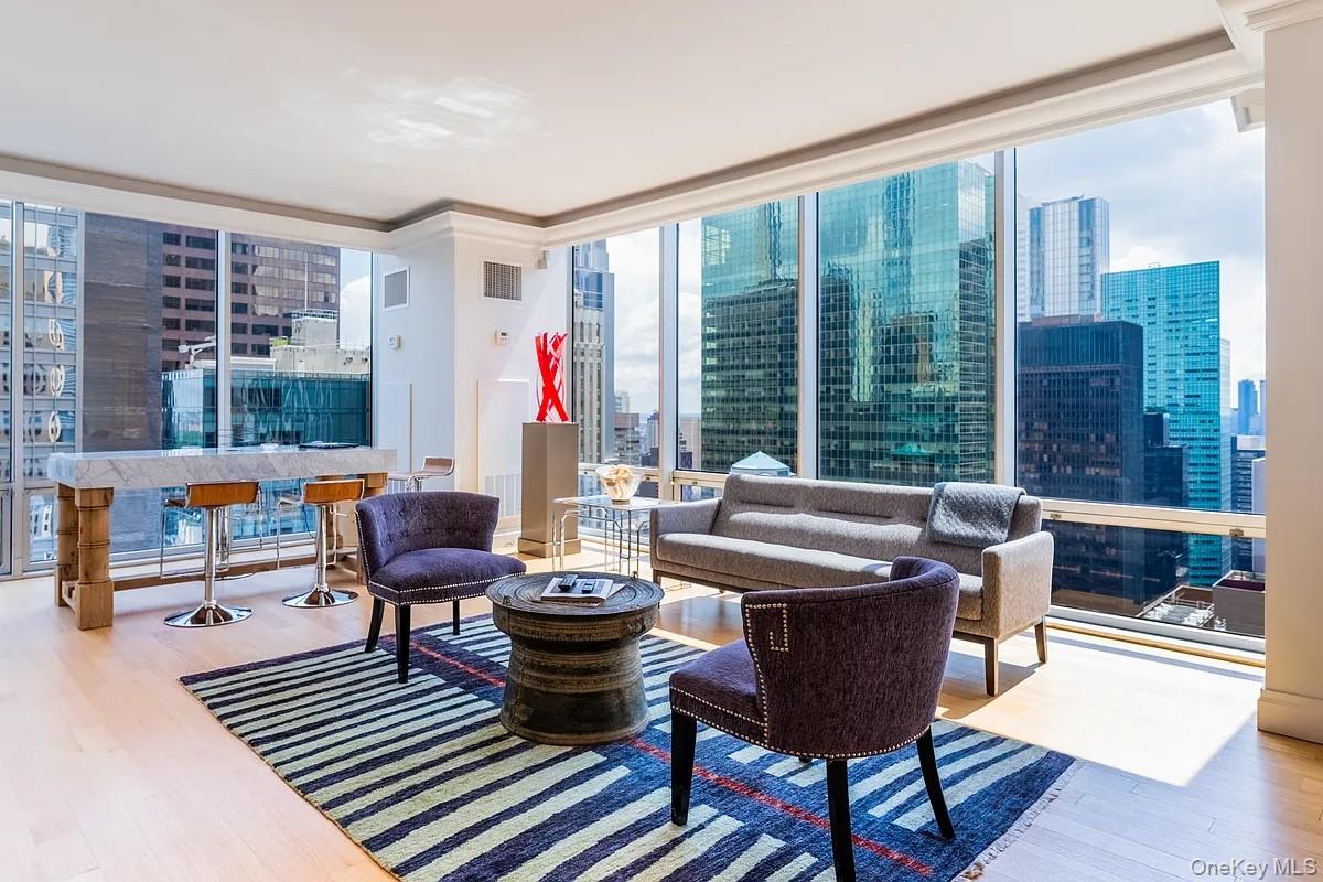 641 5th Avenue, Unit 33D Manhattan, NY 10022 - Photo 1 of 2 a living room with furniture a rug and a large window