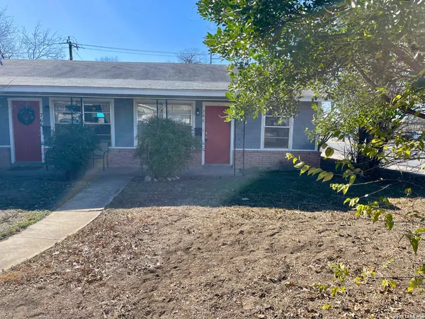 a front view of a house with a yard and a garden