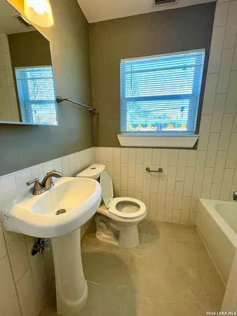 a bathroom with a sink a toilet and mirror