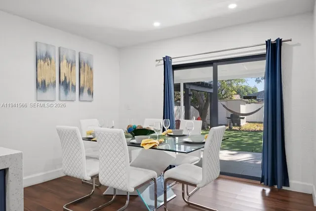 a dining room with furniture window and wooden floor