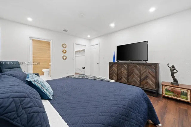 a bedroom with a bed and a flat screen television