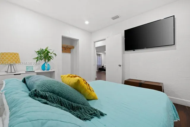 a bedroom with a bed and a flat screen tv