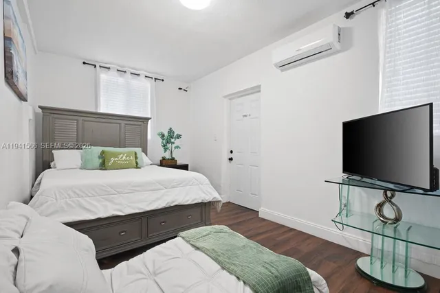a bedroom with a bed and flat screen tv