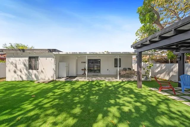 a view of a house with backyard sitting area and garden