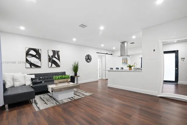 a living room with furniture and kitchen view