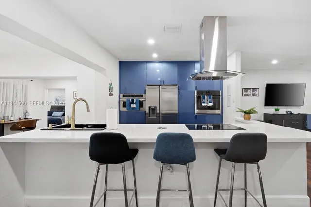 a living room with furniture a flat screen tv and kitchen view