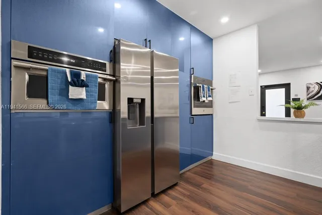 a metallic refrigerator freezer sitting inside of a kitchen