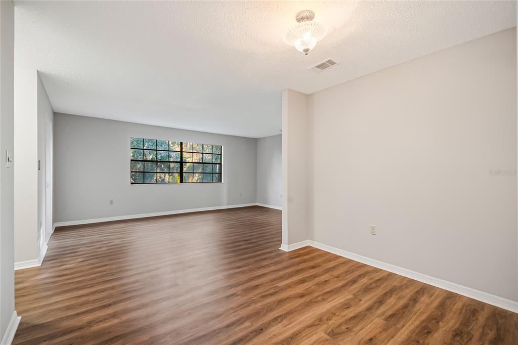 500 Newell Hill Road, Unit 106D Leesburg, FL 34748 - Photo 11 of 45 a view of an empty room with wooden floor and a window