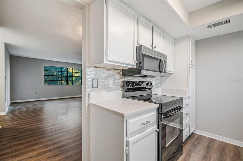 500 Newell Hill Road, Unit 106D Leesburg, FL 34748 - Photo 13 of 45 a kitchen with wooden cabinets and a stove top oven