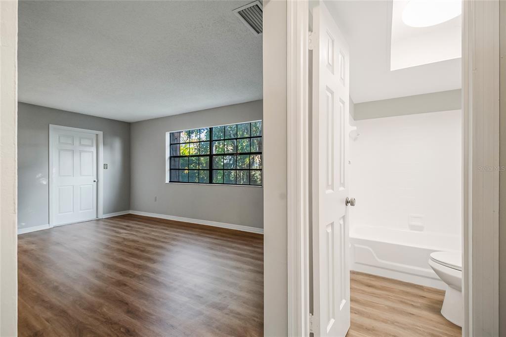 500 Newell Hill Road, Unit 106D Leesburg, FL 34748 - Photo 19 of 45 a view of an empty room with wooden floor and a window